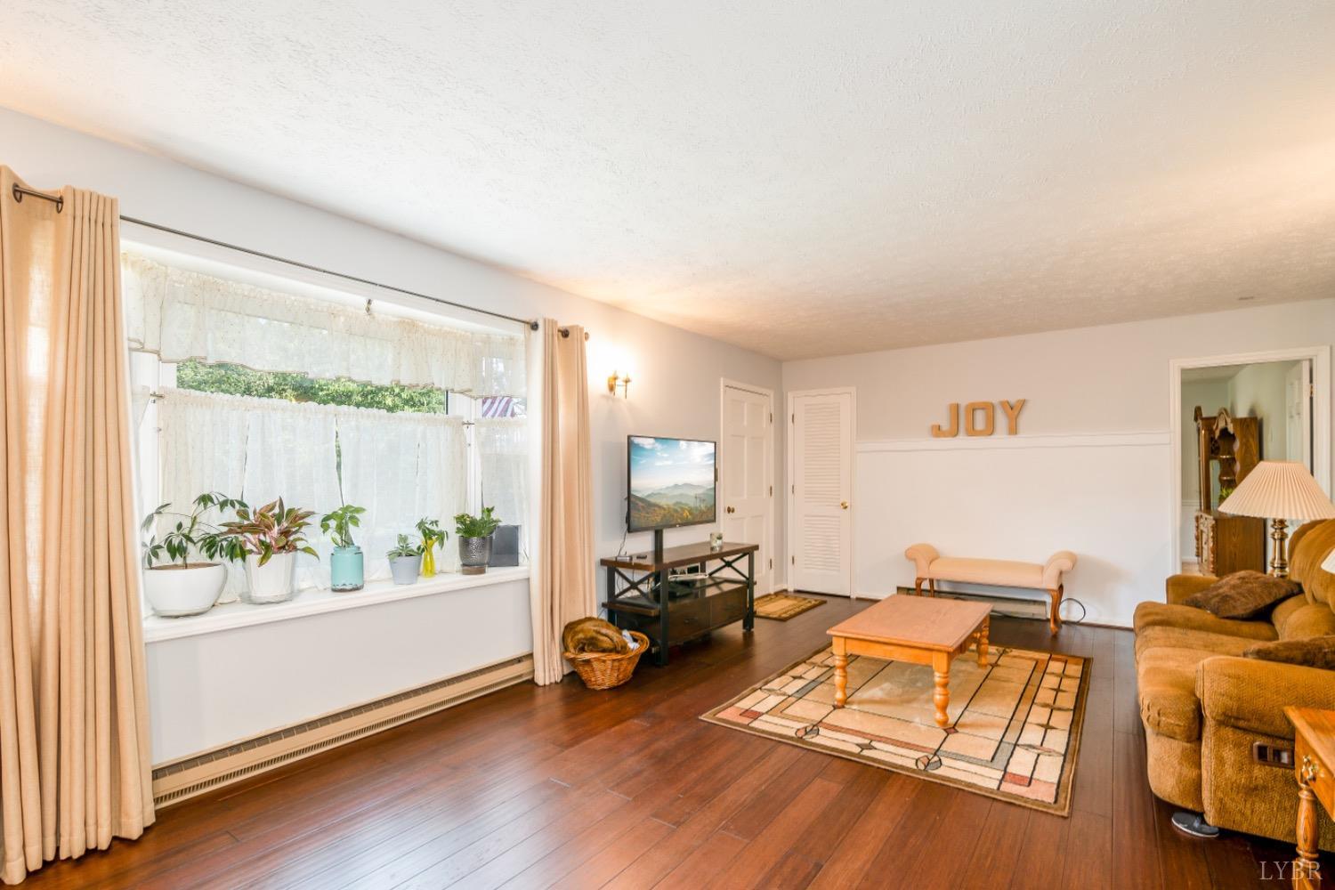 1097 Hummingbird Lane Spout Spring, VA 24593 - Photo 8 of 44 a living room with furniture and a wooden floor