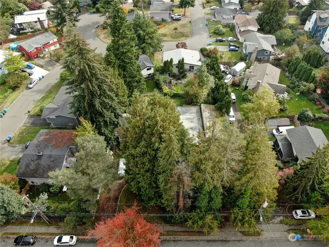 an aerial view of a residential apartment building with a yard and parking spaces