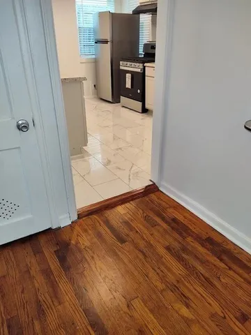 a view of empty room with wooden floor