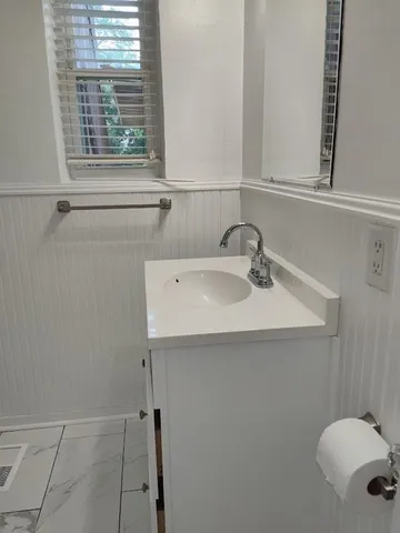 a bathroom with a sink a window and a shower