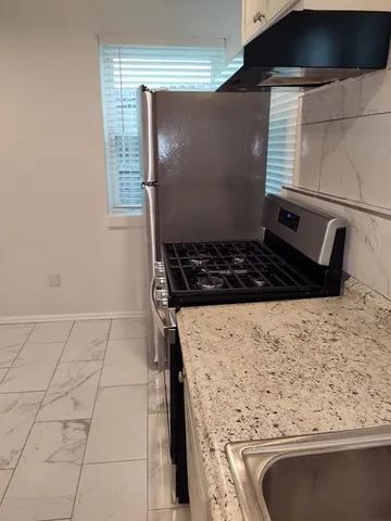 a bathroom with a granite countertop sink and cabinets