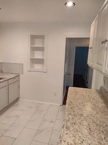 a kitchen with granite countertop a sink and a stove