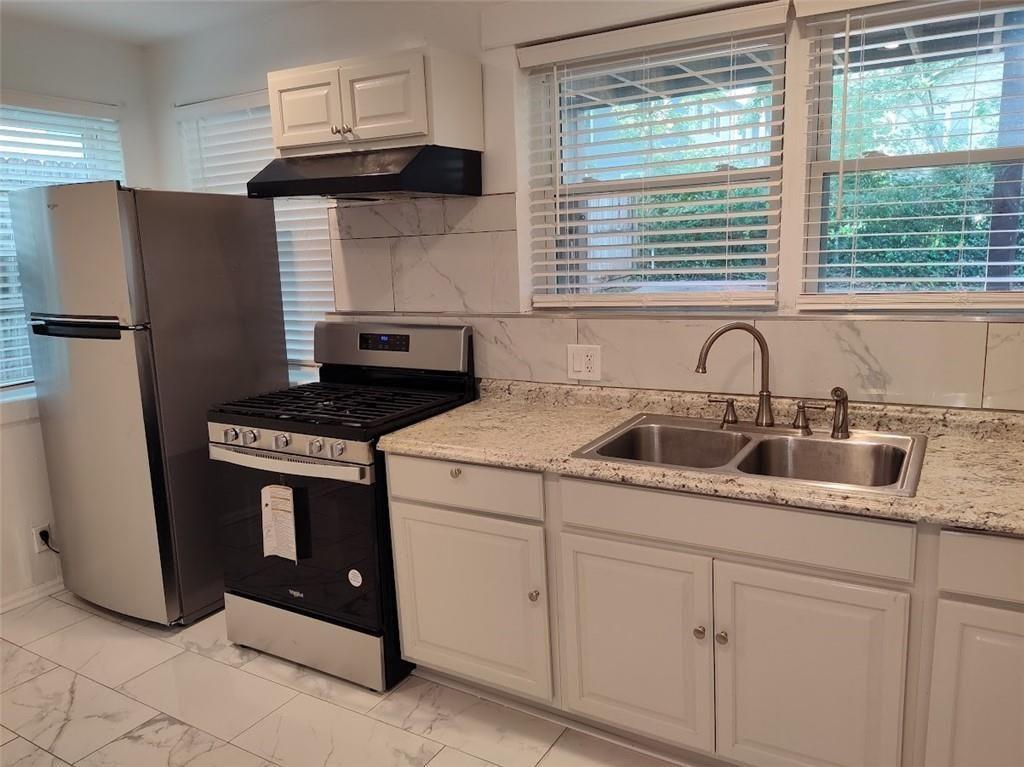 223 Sterling Street, Unit A Decatur, GA 30030 - Photo 35 of 36 a kitchen with stainless steel appliances granite countertop a sink stove and refrigerator