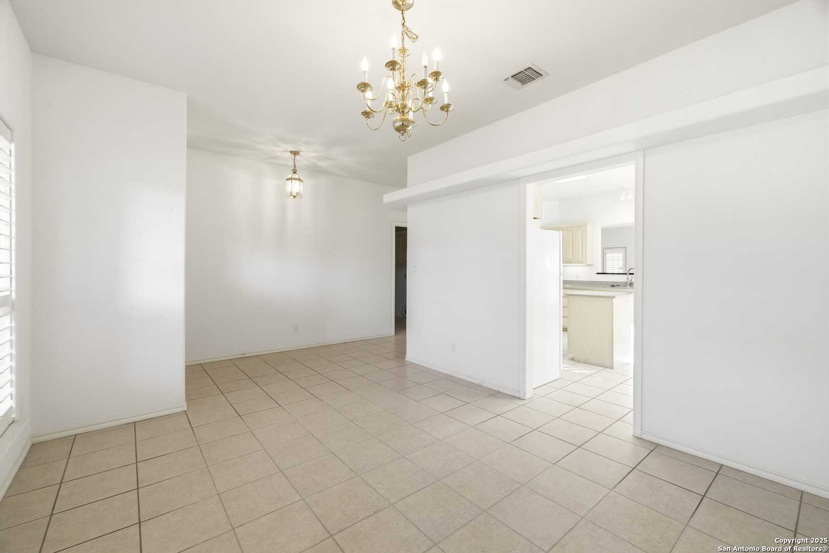 129 Los Cedros Loop Kerrville, TX 78028 - Photo 22 of 26 an empty room with kitchen and chandelier fan