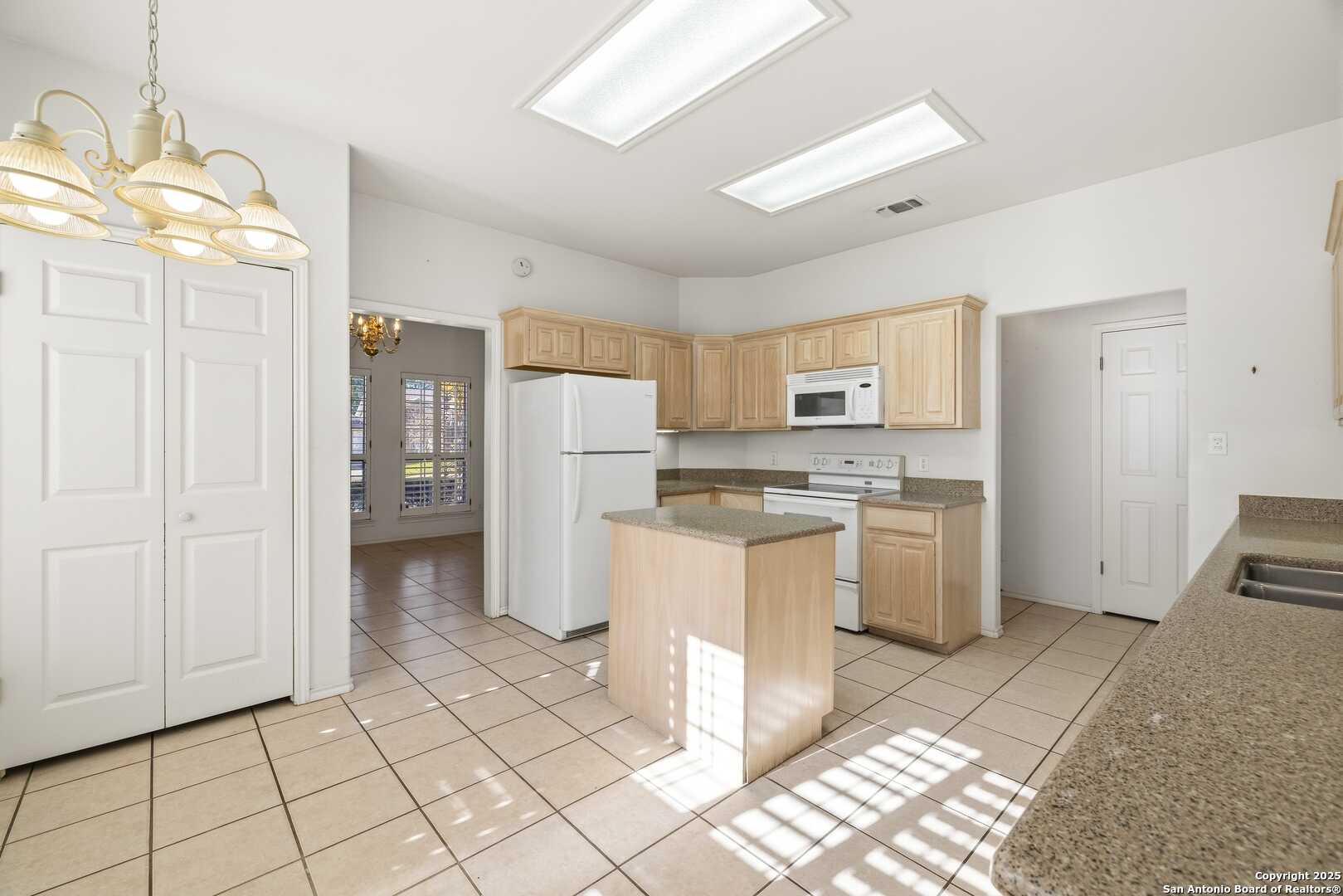 129 Los Cedros Loop Kerrville, TX 78028 - Photo 5 of 26 a kitchen with white cabinets and refrigerator