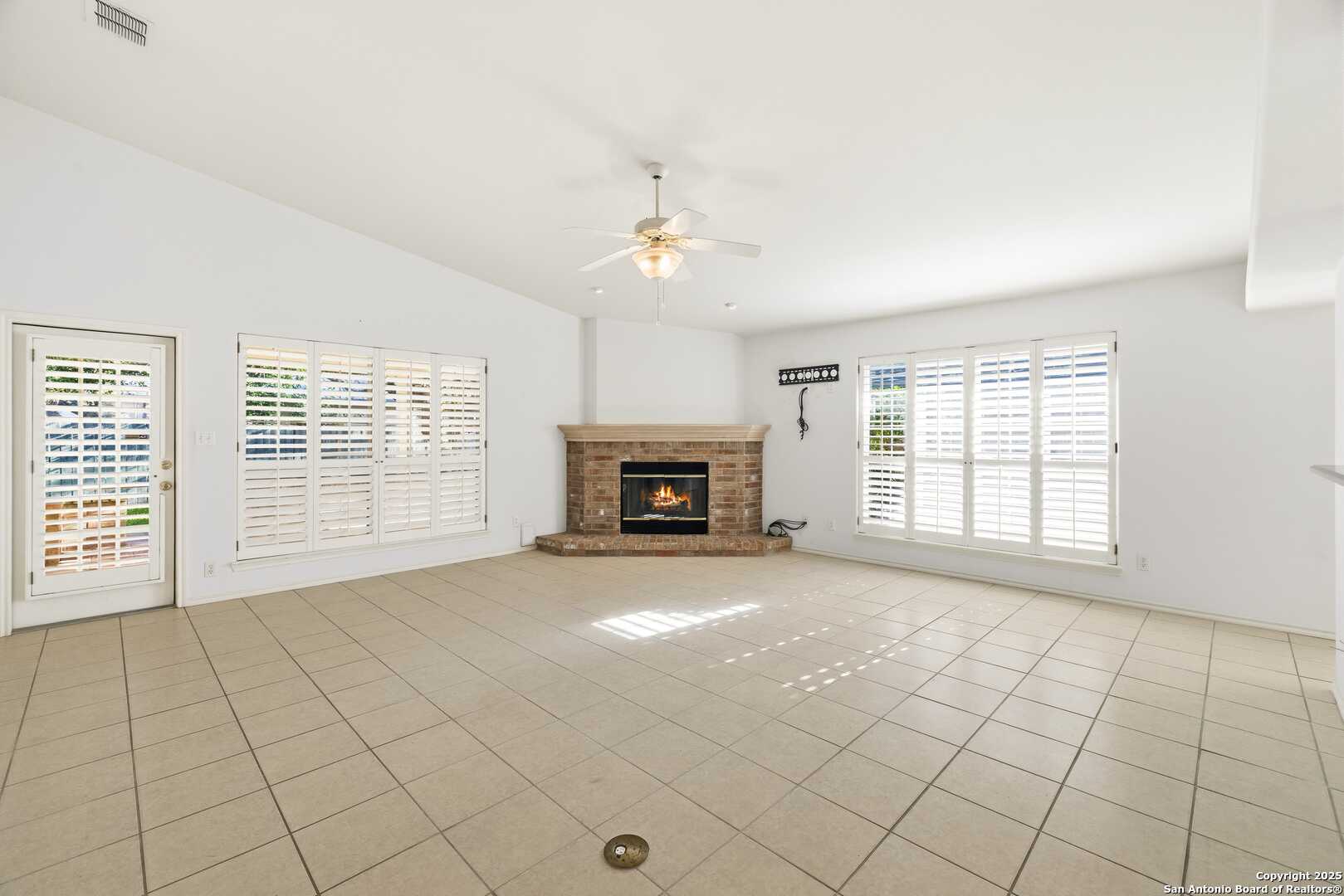 129 Los Cedros Loop Kerrville, TX 78028 - Photo 8 of 26 a view of an empty room with a fireplace and a window