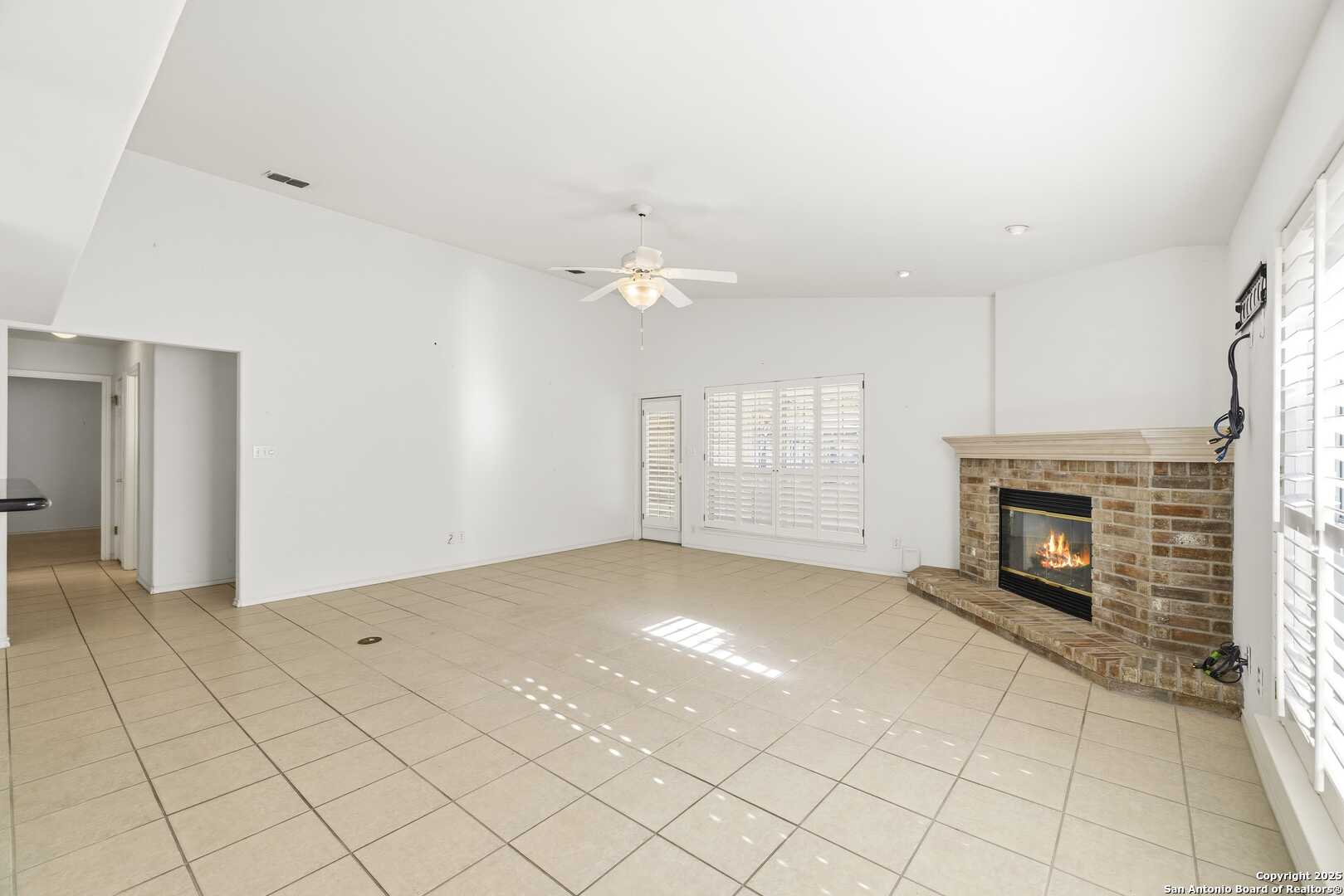 129 Los Cedros Loop Kerrville, TX 78028 - Photo 9 of 26 an empty room with fireplace and fan