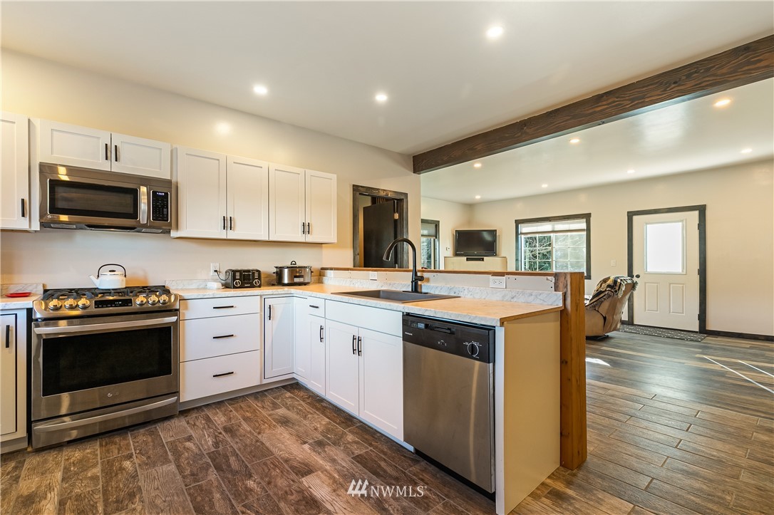 5651 Putnam Road Everson, WA 98247 - Photo 15 of 38 a kitchen with granite countertop a stove top oven sink and cabinets