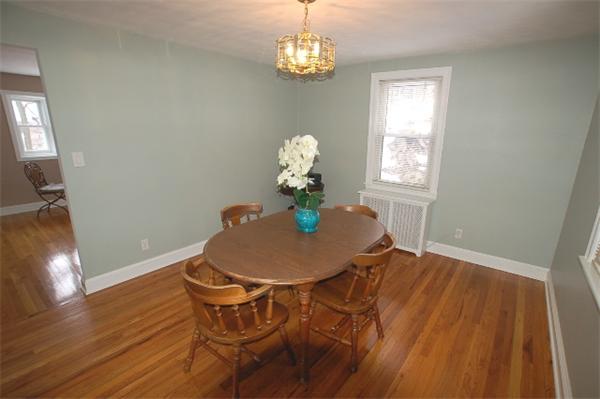 26 Fern Road Medford, MA 02155 - Photo 10 of 27 a dining room with wooden floor a chandelier a wooden table and chairs
