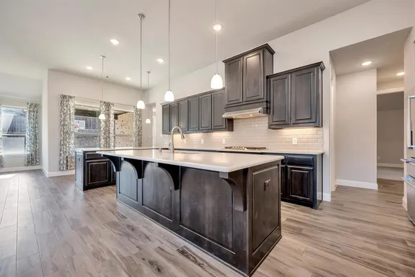 a large kitchen with lots of counter space a sink appliances and cabinets