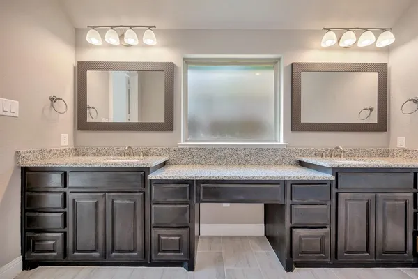 a spacious bathroom with a granite countertop sink and a mirror