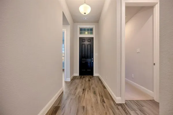 a view of a hallway with wooden floor and closet