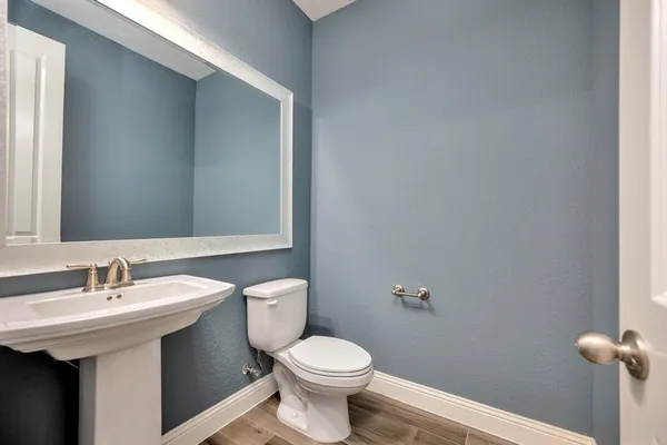 a bathroom with a sink a toilet and mirror