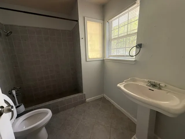 a bathroom with a sink toilet and shower