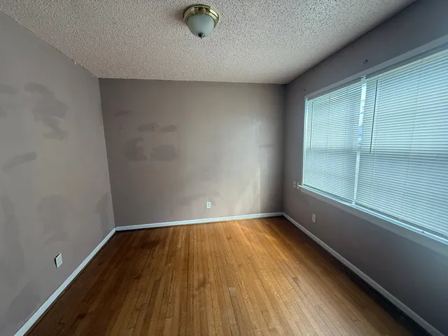 a view of a room with wooden floor and window
