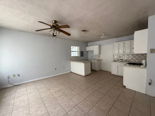 a kitchen with stainless steel appliances granite countertop white cabinets and window
