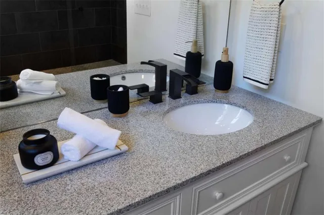 a bathroom with a granite countertop sink and a mirror