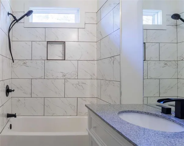 a bathroom with a granite countertop sink and shower