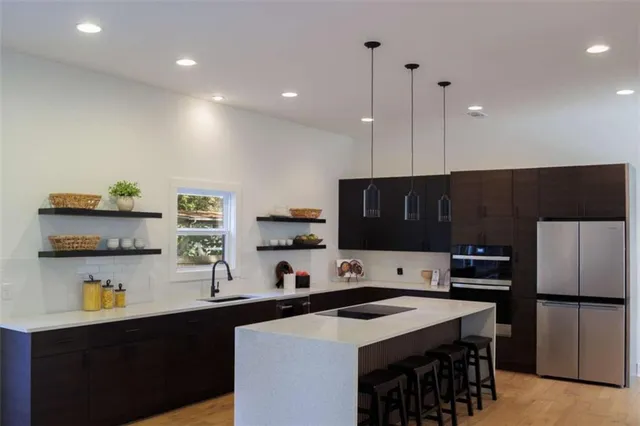 a kitchen with stainless steel appliances a stove refrigerator sink and cabinets