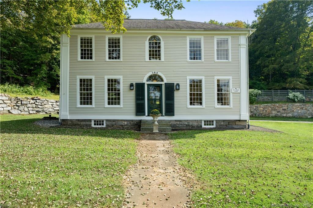 a view of a house with backyard and sitting area