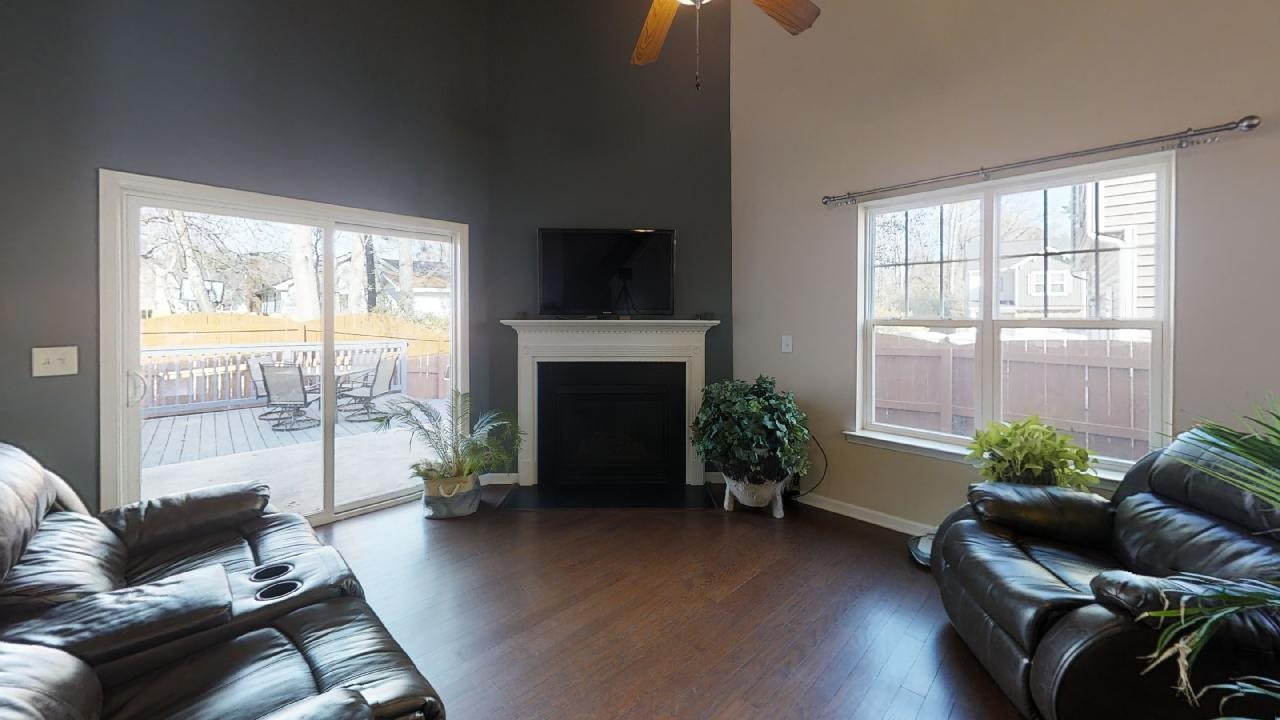 Contemporary natural gas fireplace with vaulted ceilings and sliding door to outside deck/garden area Living Room