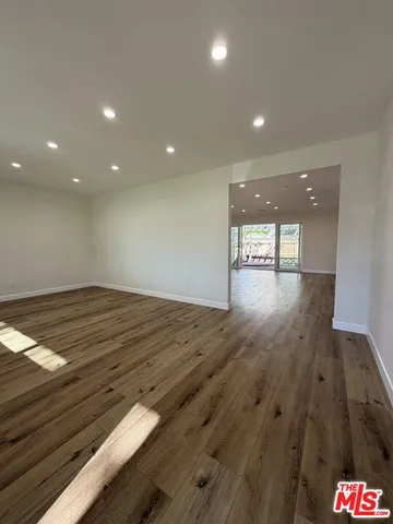 a large kitchen with stainless steel appliances granite countertop a large stove a sink dishwasher and a refrigerator with wooden floor