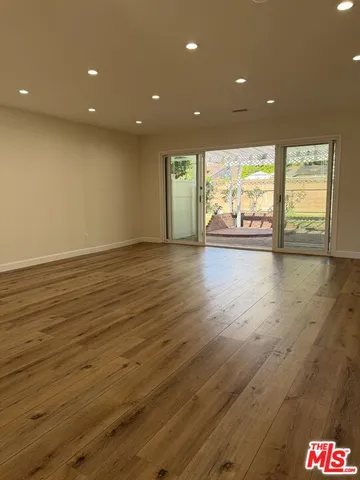 a large kitchen with stainless steel appliances granite countertop a lot of counter space and wooden floors