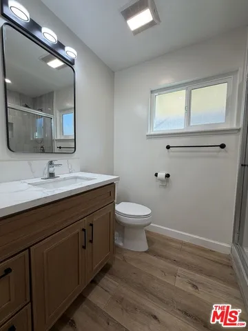 a view of a kitchen with wooden floor and a refrigerator