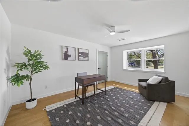 a view of a livingroom with wooden floor and a bathroom