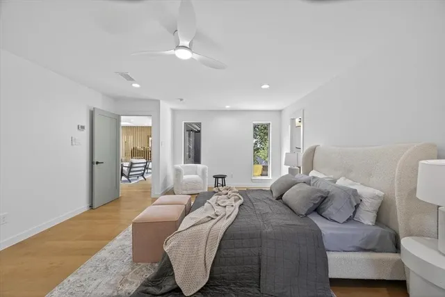 a spacious bedroom with a bed a couch and potted plant with the walls