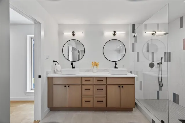 a spacious bathroom with a double vanity sink mirror and a bathtub