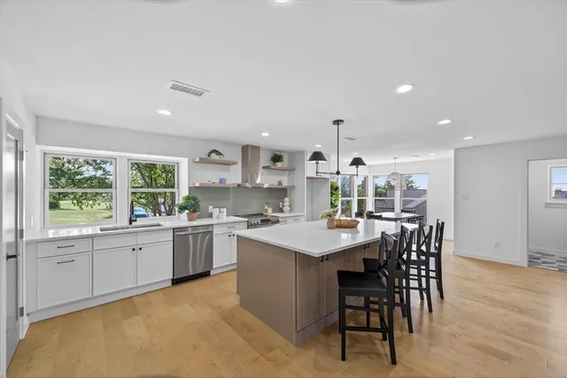 a kitchen with stainless steel appliances granite countertop a stove and a refrigerator a sink with wooden floor