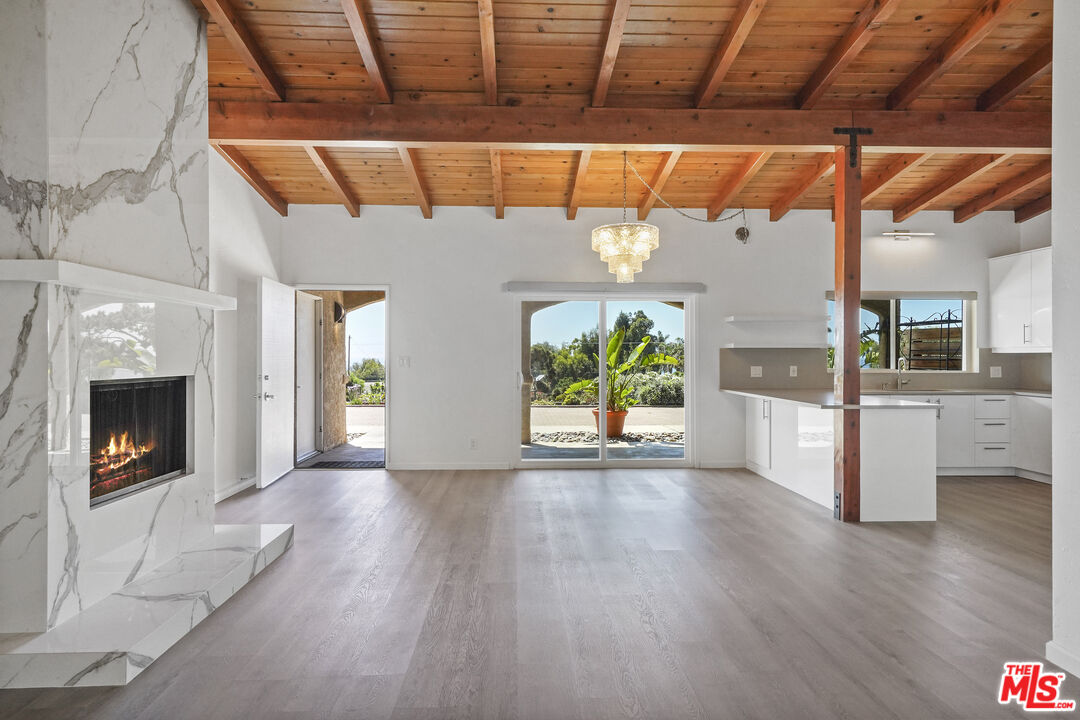 31259 Bailard Road Malibu, CA 90265 - Photo 6 of 41 a view of empty room with wooden floor and a fireplace