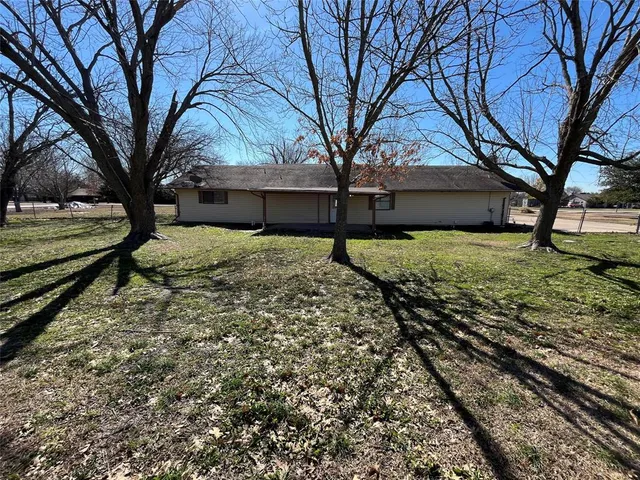 a house is sitting in middle of the yard