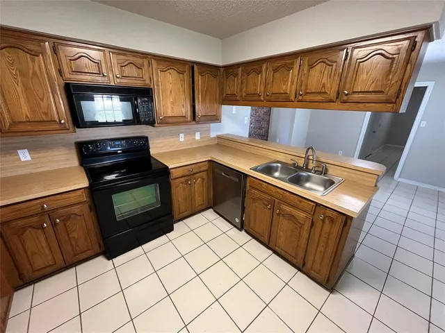 a kitchen with a refrigerator a stove top oven and cabinets