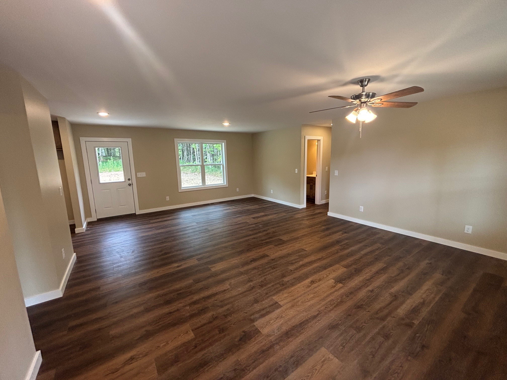 2303 Charley Davis Road Goodspring, TN 38460 - Photo 12 of 16 an empty room with wooden floor chandelier fan and windows
