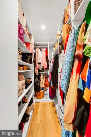 a view of walk in closet with clothes and shoes