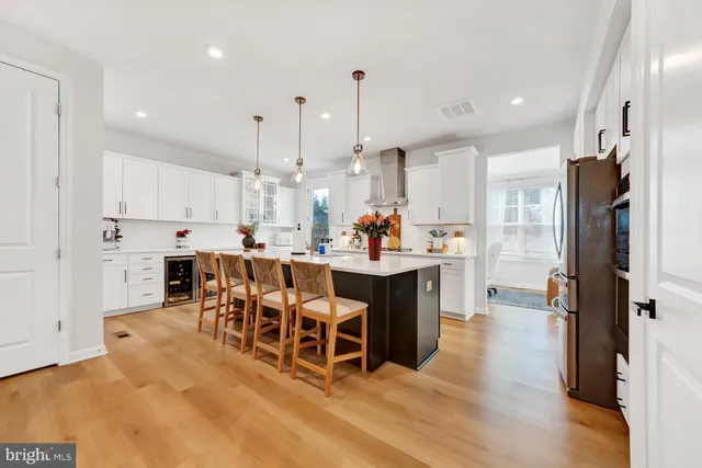 a kitchen with stainless steel appliances kitchen island a refrigerator and a dining table