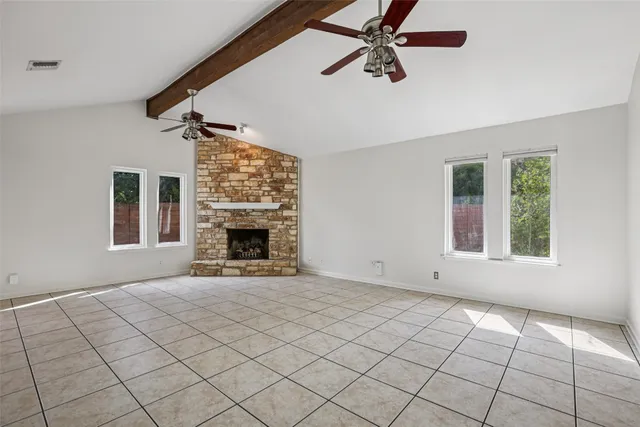 a view of an empty room with window and fire place