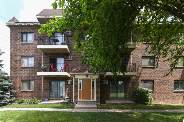 front view of a brick house with a yard