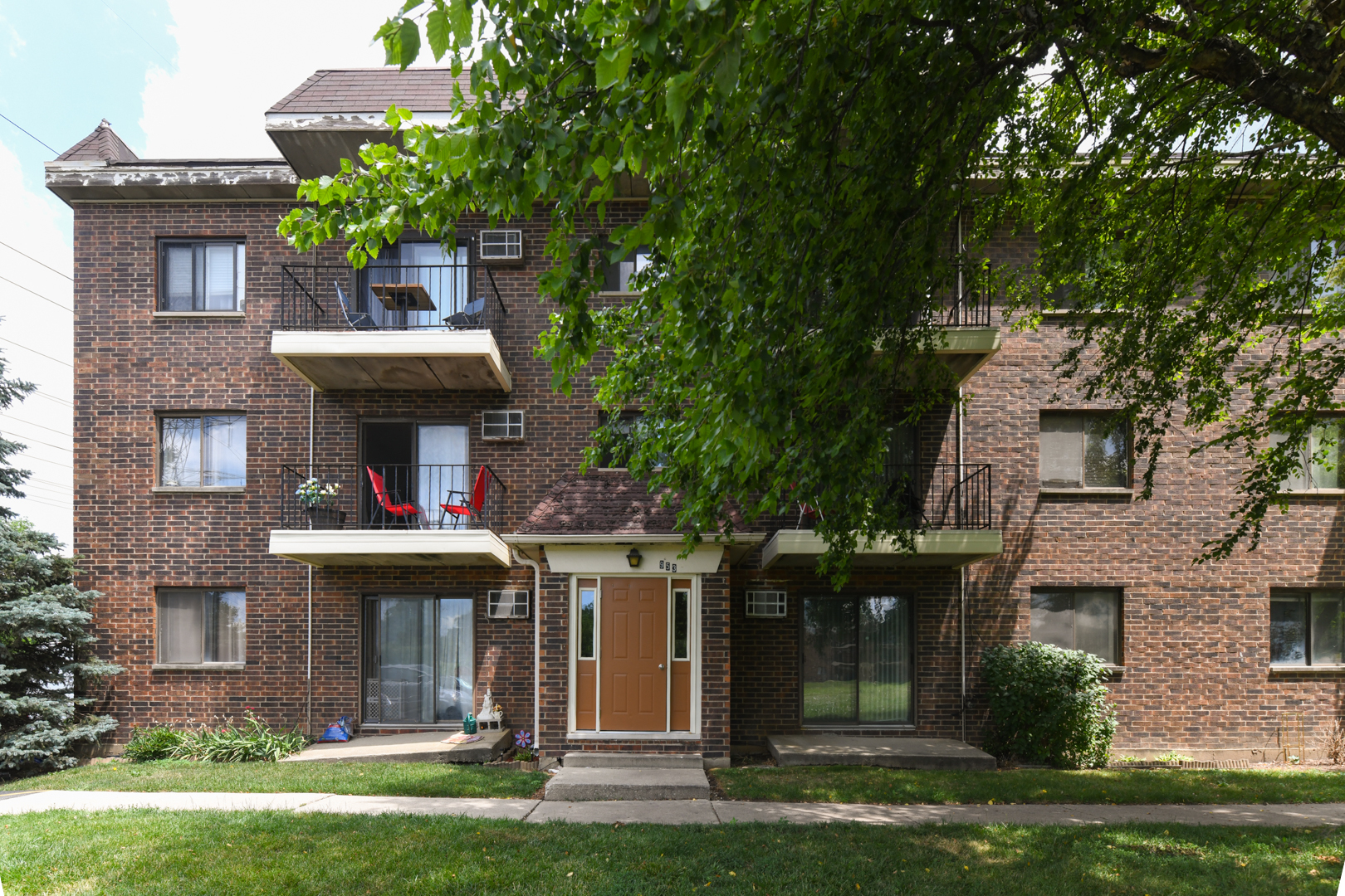 front view of a brick house with a yard