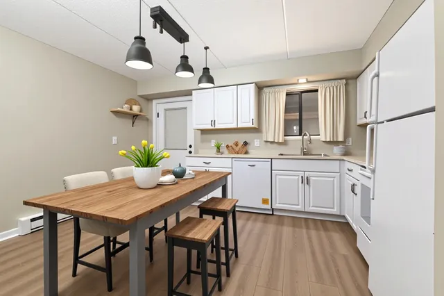 a kitchen with a table chairs refrigerator and cabinets