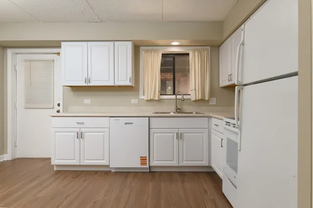 a kitchen with stainless steel appliances granite countertop a sink and a refrigerator