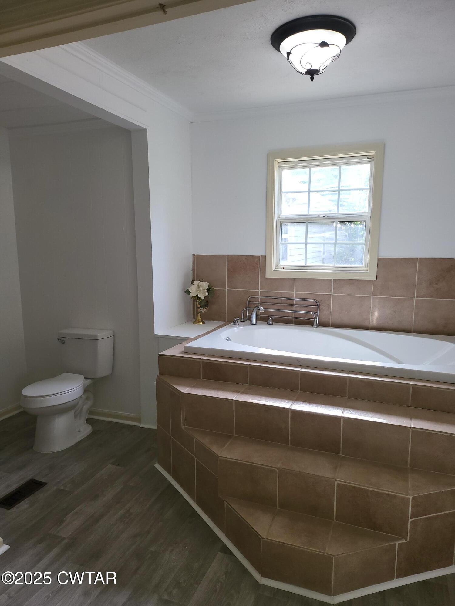 200 Cross Street Bolivar, TN 38008 - Photo 9 of 12 a bathroom with a granite countertop sink a toilet and a window
