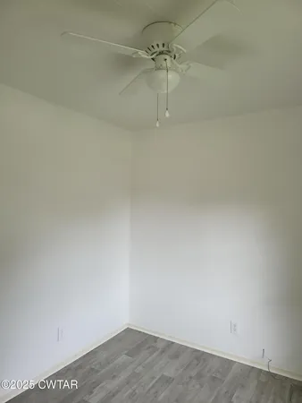 a view of a room with wooden floor and fan