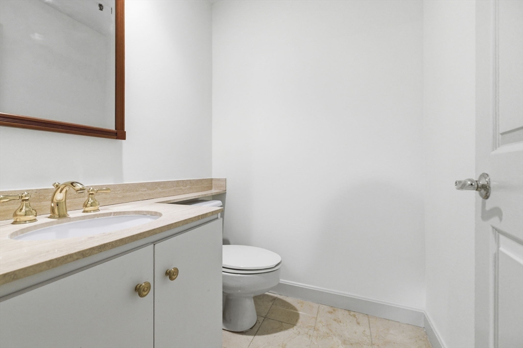 416 Commonwealth Avenue, Unit 312 Boston, MA 02215 - Photo 13 of 24 a bathroom with a granite countertop toilet sink and mirror