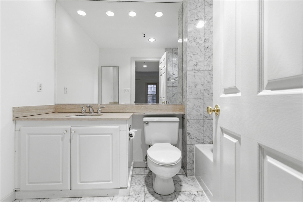 416 Commonwealth Avenue, Unit 312 Boston, MA 02215 - Photo 16 of 24 a bathroom with a toilet a sink and mirror