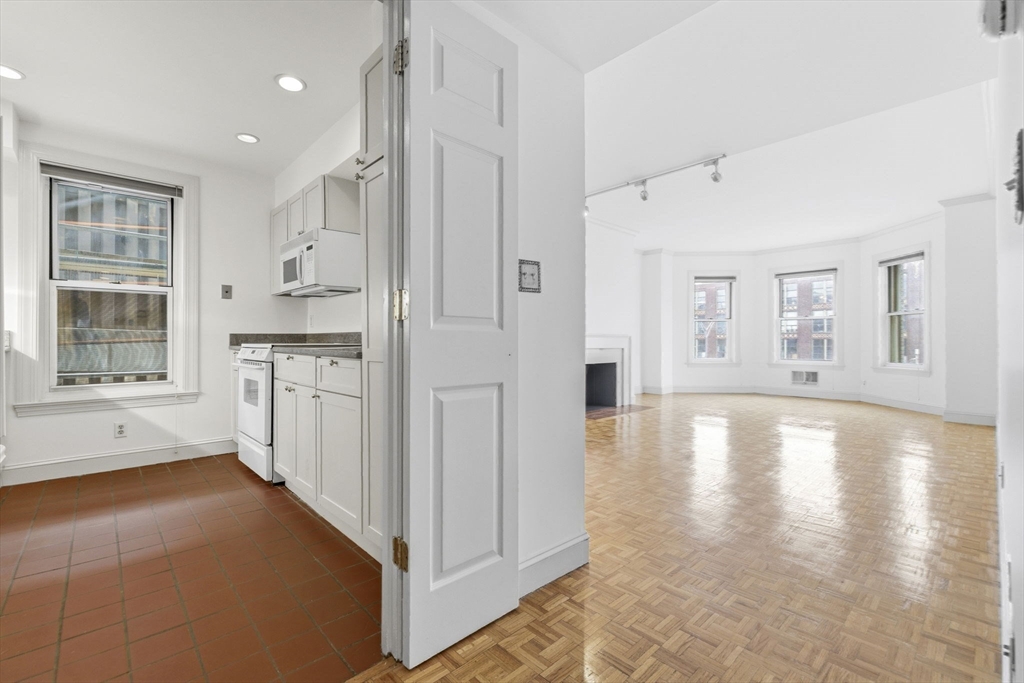 416 Commonwealth Avenue, Unit 312 Boston, MA 02215 - Photo 8 of 24 a view of a kitchen with a stove top oven a sink a refrigerator and white cabinets