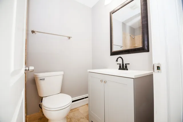 a bathroom with a toilet sink and mirror