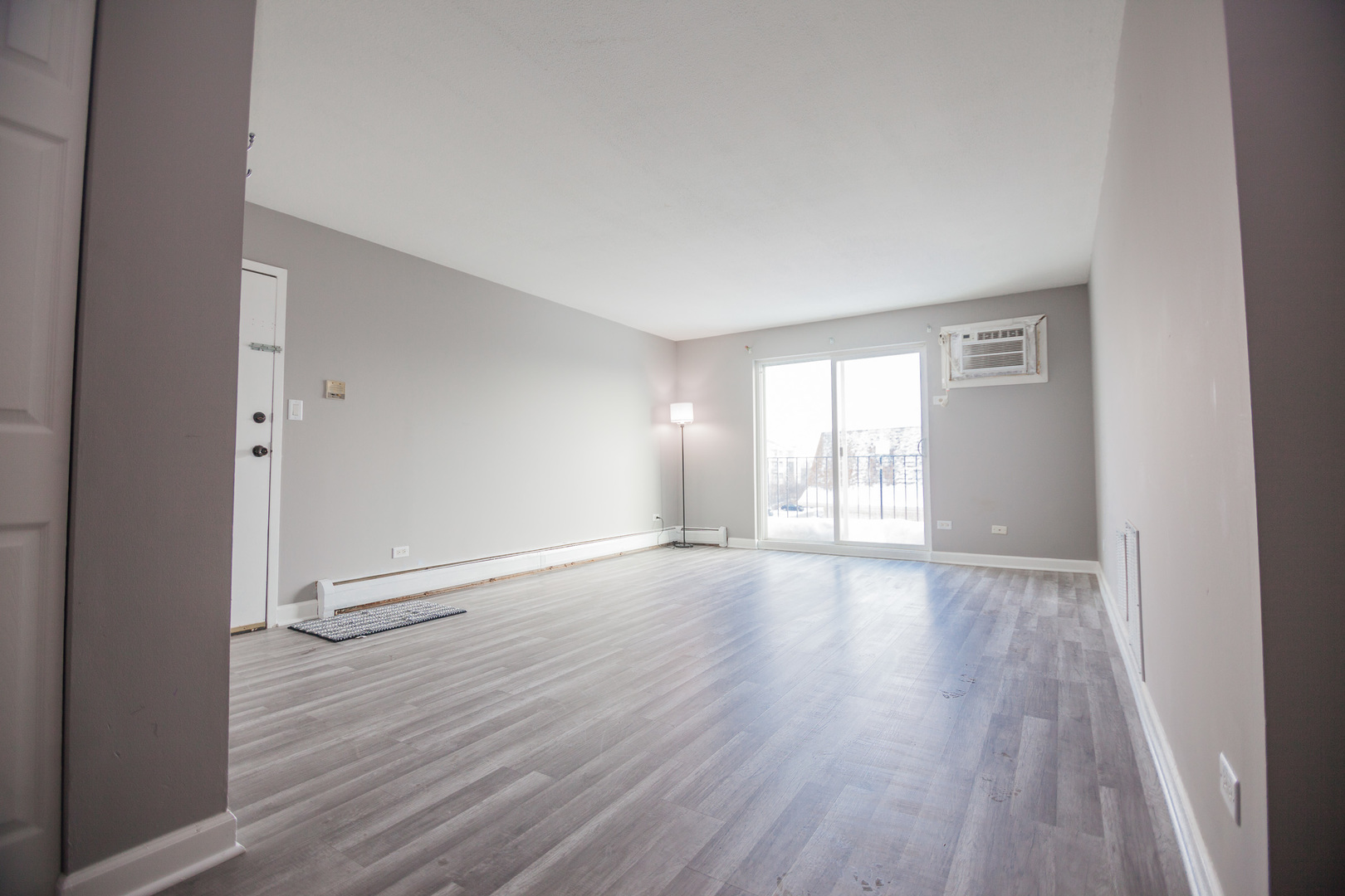 1111 Bloomingdale Road, Unit 2B Glendale Heights, IL 60139 - Photo 5 of 15 a view of an empty room with wooden floor and a window